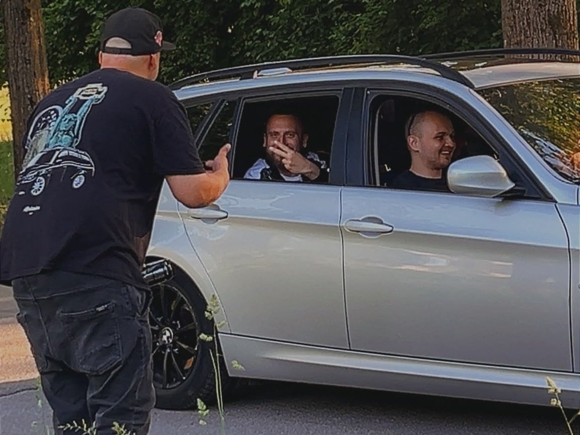 Talking to two drivers through the window of a silver BMW estate